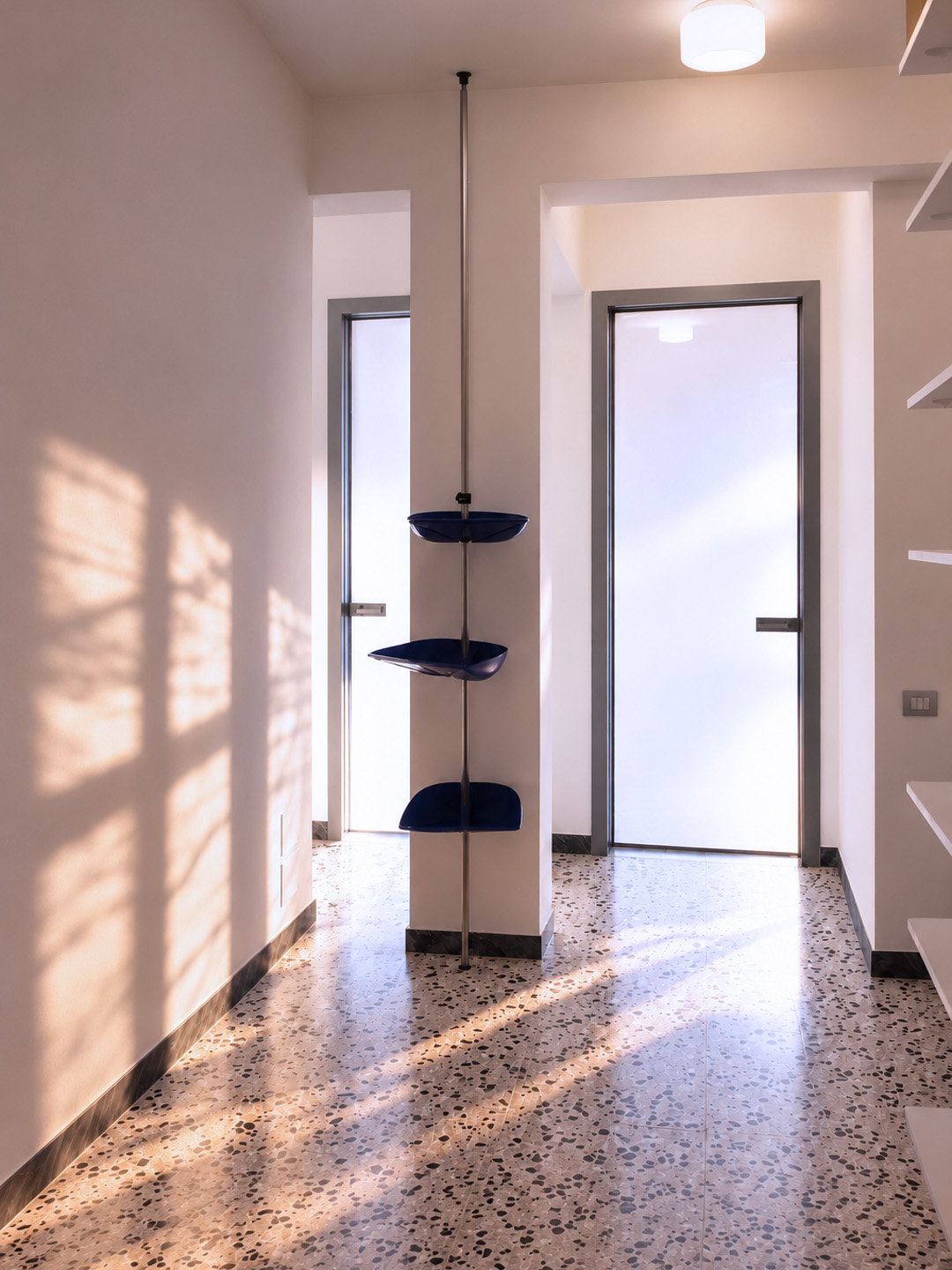 Ingresso dell’appartamento a Montesacro con porte vetrate, pavimento originale in graniglia chiara e luce naturale.